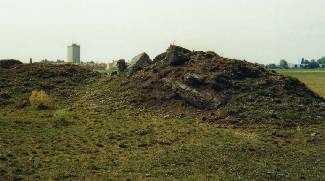 Gesprengte Munitionsbunker, im Hintergrund die Heidesiedlung (ehemaliger Standort mehrerer 
						Baracken)